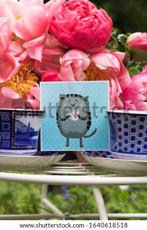 Vertical Image: Beautiful Bouquet of Peonies and Two Blue Cups are on Table in Garden. Concept: I Love You. Romantic Touching Still Life Vibrant Pleasant Valentine Composition, Close-up View.