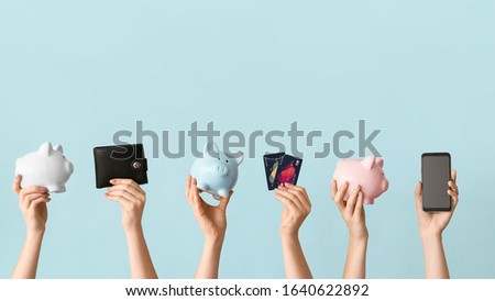 Female hands with piggy banks, credit cards, wallet and mobile phone on color background. Concept of online banking Royalty-Free Stock Photo #1640622892