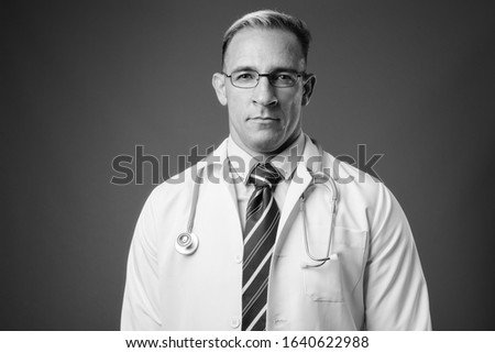 Studio shot of man doctor against gray background