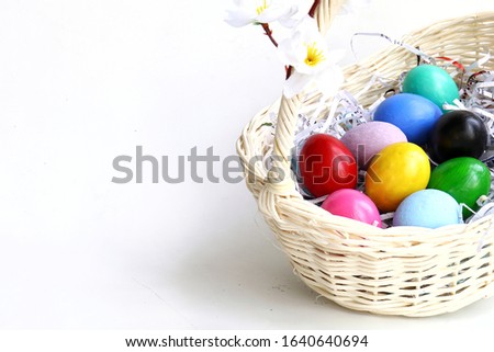 Colorful easter eggs in white basket isolated on white background, more space for copy paste
