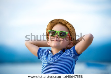 Stylish child boy in sunglasses near palm. Cool kid on summer vacation Royalty-Free Stock Photo #1640647558