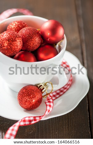 Small red Christmas balls in a white cup