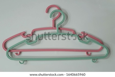 Closed up two hangers in pink and green with white background