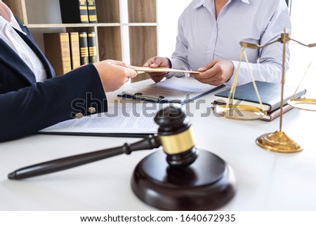 Professional Female lawyer discussing negotiation legal case with client meeting with document contact in courtroom, law and justice concept.