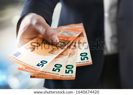 Business Man give a spread of euros cash over bank background. Euro currency detail. Money Banknotes close up.