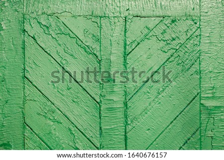 The old wooden surface is painted with green oil paint. Close-up. Texture. Abstract background