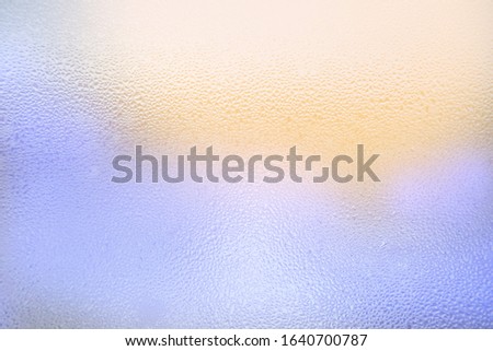 Abstract blue-yellow background. Water drops on the glass.