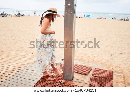Young beautiful woman smiling happy cleaning feet from sand at the beach