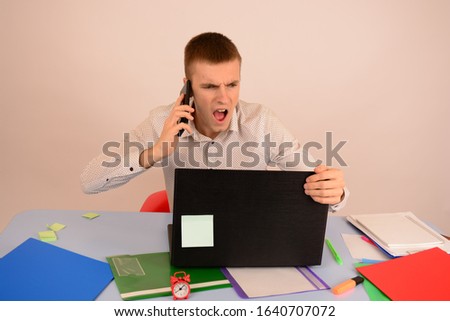 angry business man talking on the phone looking at a laptop
