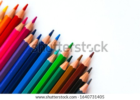 bright multi-colored flat lay pencils for drawing on a white background, place for text