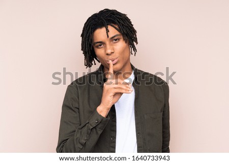 Young African American man over isolated background showing a sign of silence gesture putting finger in mouth