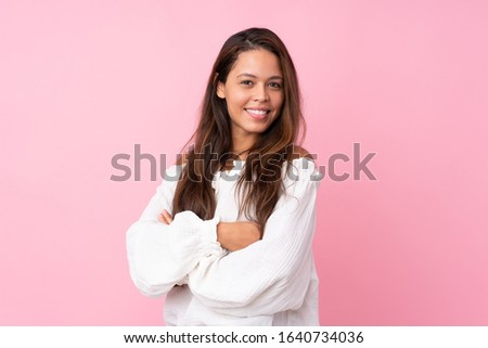 Young Brazilian girl over isolated pink background with arms crossed and happy