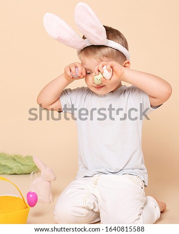 Caucasian tired little boy as an Easter bunny. Happy easter greetings. Concept of human emotions, facial expression, holidays. Copyspace.