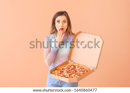 Portrait of surprised young woman with pizza on color background