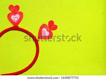 Red hair band and heart shape on the bright green paper for background image