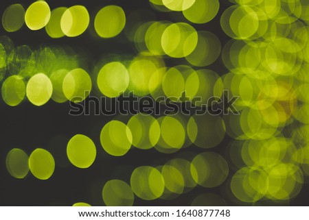 Green abstract bokeh with black background. Defocused