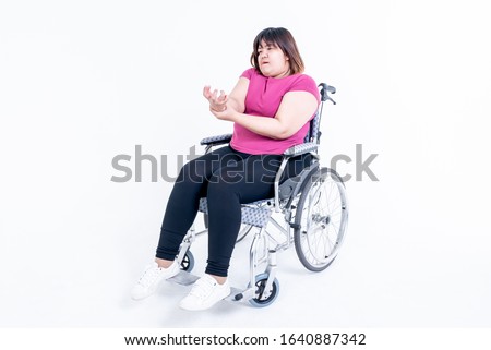 Portrait images, Asian fat woman sitting on a wheelchair His hands are kinking due to a nervous system illness and paralysis or Hemiplegia, On white background to health care concept. Royalty-Free Stock Photo #1640887342