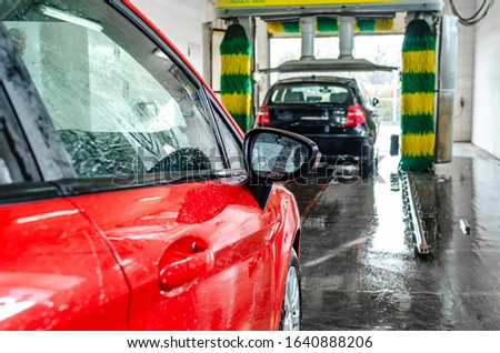 Red car at an automatic car wash.