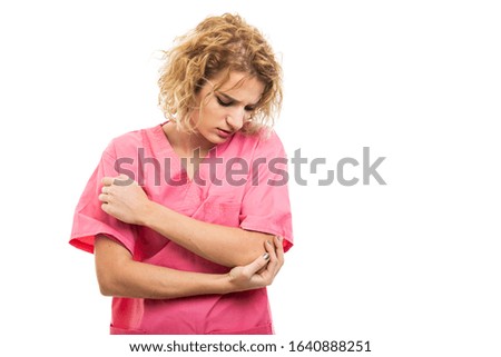 Portrait of nurse wearing pink scrub holding elbow like hurting isolated on white background with copy space advertising