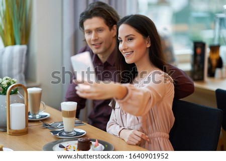 Young Couple taking selfie In Cafe