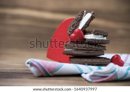 chocolate chip cookie sandwich on a colored napkin on a wooden background. wooden and red hearts. Happy Valentine's day. beautiful picture with biscuits. texture.