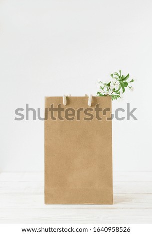 Brown craft paper bag with handles.White background.Fresh flowers.Recycled paper.