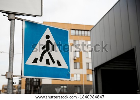 pedestrian crossing street sign on the background of buildings