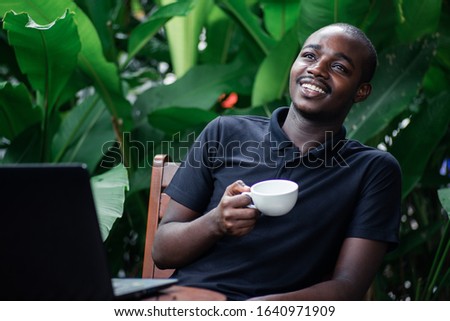 African man using a laptop computer outside a coffee cafe