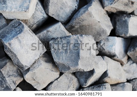 Photo with pattern texture of stones. The natural texture of the ground is cold dark in color. Picturesque stones, pavers, pebbles