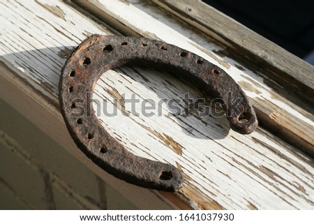Rusty metal horseshoe lying on a cracked board