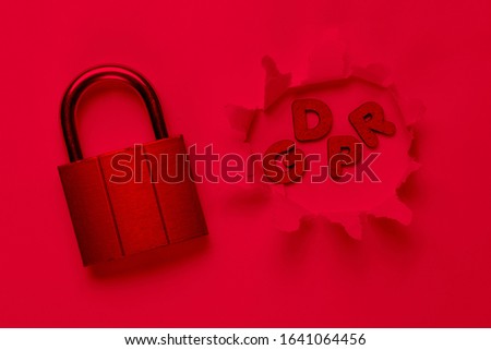 Lock and the word gdpr in a torn hole. Red neon light