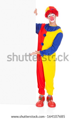 Portrait Of A Happy Joker Holding Blank Placard Over White Background
