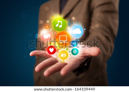 Young business man in suit presenting colorful technology icons and symbols