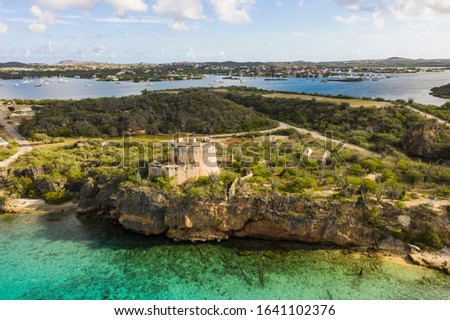 Aerial view of coast of Curaçao in the Caribbean Sea with turquoise water, cliff, beach and beautiful coral reef over Fort Beekenburg