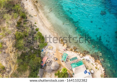 Aerial view of coast of Curaçao in the Caribbean Sea with turquoise water, cliff, beach and beautiful coral reef over Tugboat Beach