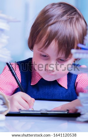 Cute business child girl signs a contract. Humorous picture