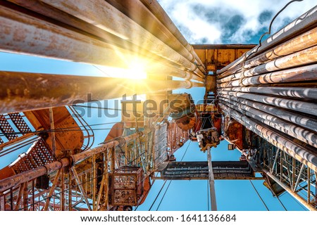 Oil and Gas Drilling Rig onshore dessert with dramatic cloudscape. Oil drilling rig operation on the oil platform in oil and gas industry Royalty-Free Stock Photo #1641136684