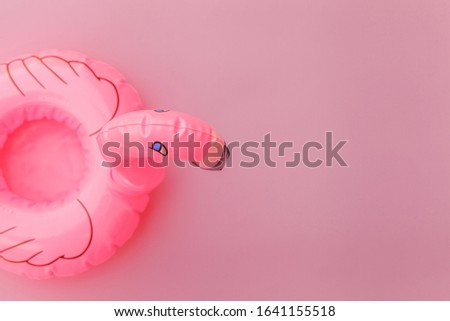 Summer beach composition. Simply minimal design with Inflatable flamingo isolated on pastel pink background. Pool float party, trendy celebrity fashion concept. Flat lay top view copy space