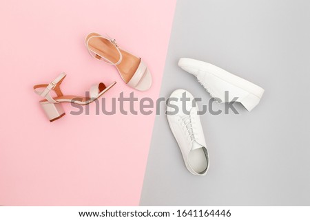 White sneakers and pink heeled sandals on grey and pink paper background. Stylish spring or summer woman's shoes in pastel colors. Trendy beauty female fashion background. Flat lay, top view. Royalty-Free Stock Photo #1641164446