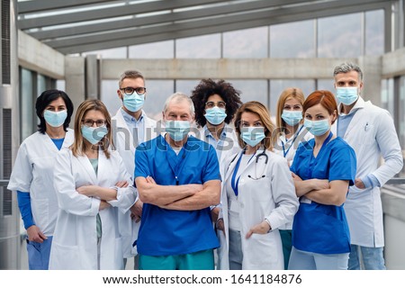 Group of doctors with face masks looking at camera, corona virus concept. Royalty-Free Stock Photo #1641184876