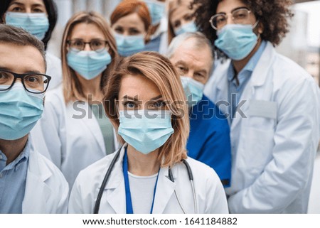 Group of doctors with face masks looking at camera, corona virus concept. Royalty-Free Stock Photo #1641184882