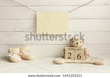 Calendar. February 26th. Day 26th of month. Teddy bear holding wood cube calendar with date of month and day. New born baby congratulation concept. Copy space.