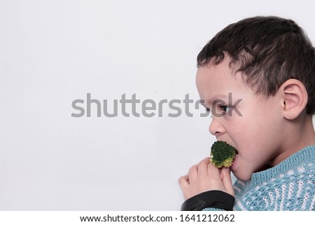 child eating broccoli on white background stock photo 