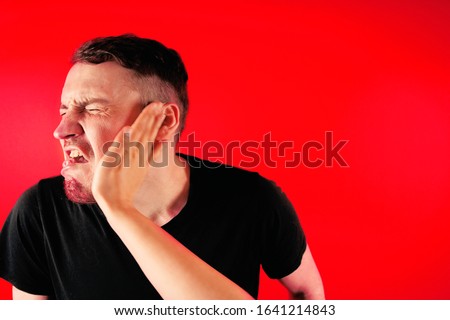 Man getting slapped on red background. Unhappy scared man getting slapped standing on red background Royalty-Free Stock Photo #1641214843