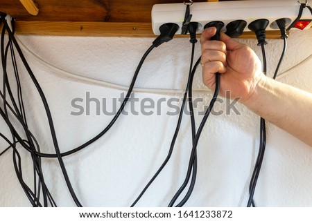 Concept of clutter in office. Unwound and tangled electrical wires under the table. Royalty-Free Stock Photo #1641233872