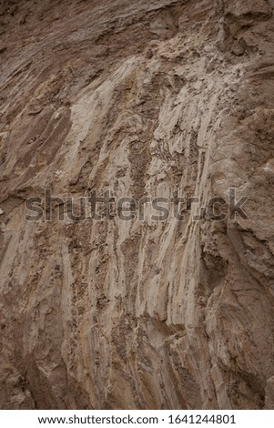 Natural blurred background, selective focus. The structure of different layers of earth in a clay quarry after geological study of the soil, environmental conservation.