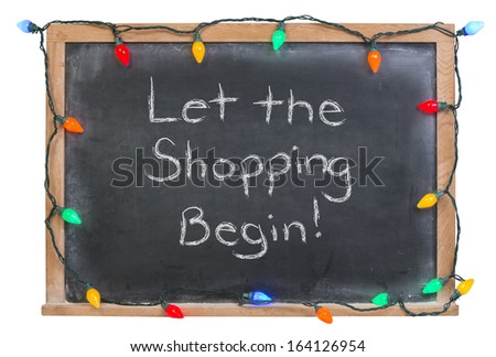 Let the shopping begin written in white chalk on a black chalkboard surrounded with colorful lights isolated on white