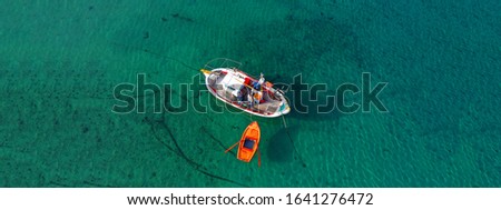 Aerial drone ultra wide photo of traditional fishing boat docked in old port of Mykonos island, Cyclades, Greece