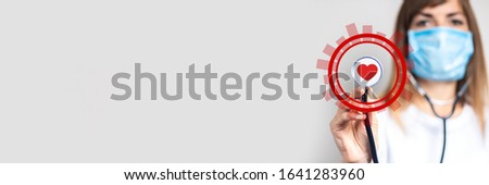 Young woman in medical mask holding a stethoscope head with heart in her hand. Added kurug icon. Added pulse and heart icon. Banner. Doctor concept, high level medical, vaccination, visit to doctor