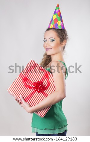 Brunette Woman in a Birthday Cap Holding Presents and Smile